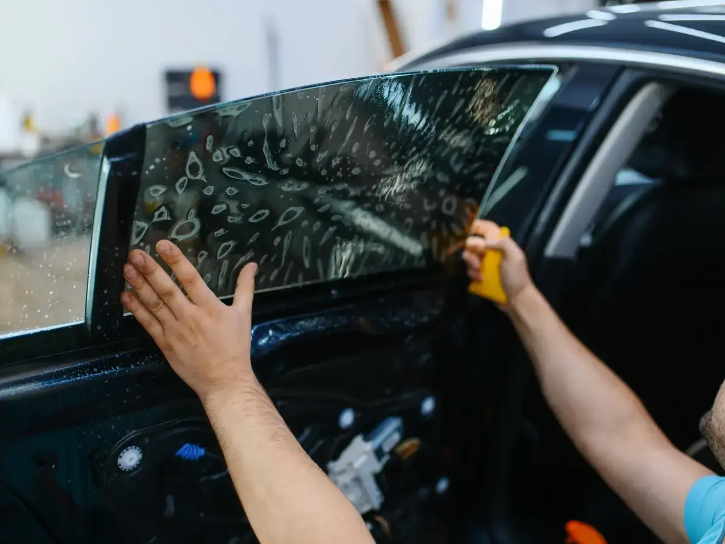auto glass technician fixing rock chip damage on car with Space Needle in Seattle background