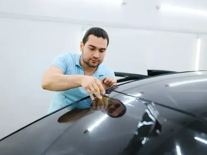 auto glass technician replacing damaged windshield at a Seahurst home driveway